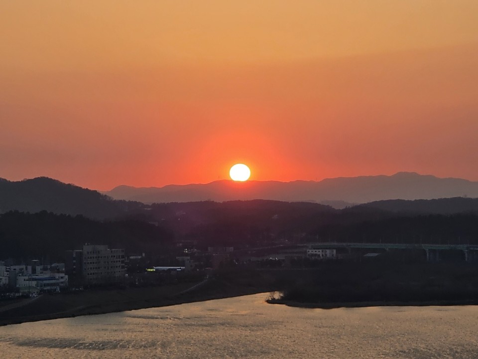 24일 오후 6시11분께 여주시 현암동 남한강에서 바라본 또렷해진 석양이 북성산 자락에 걸려 넘어가고 있다. (사진=김광섭 기자)