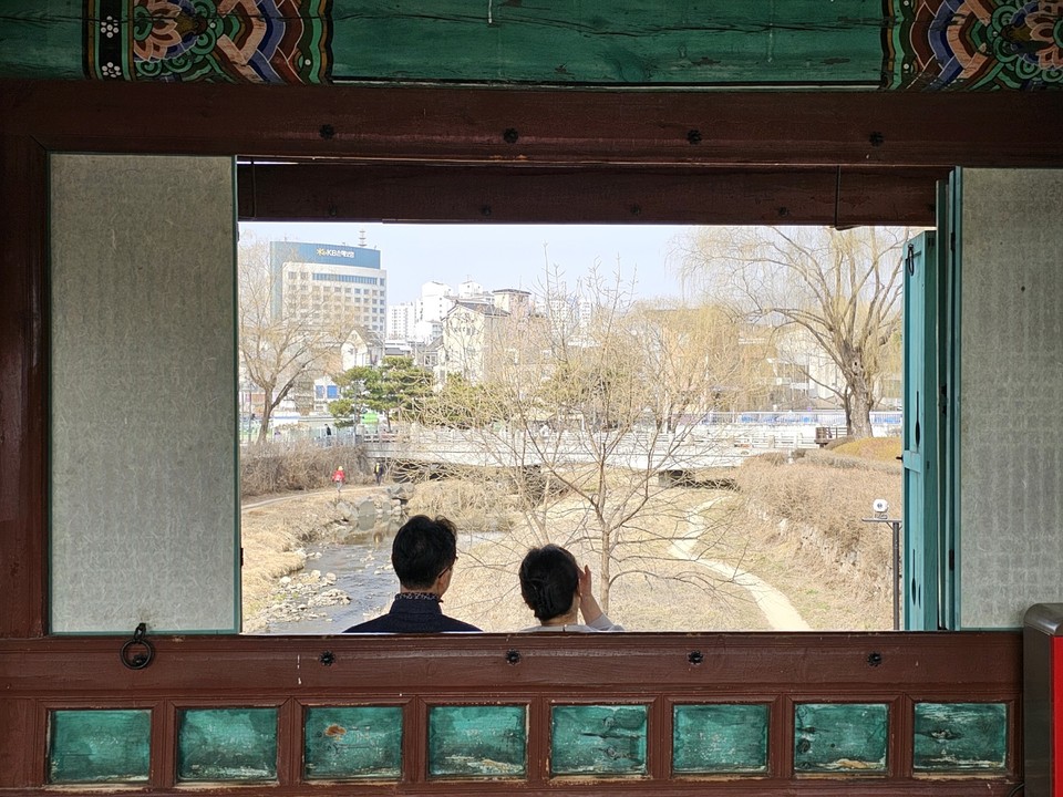 15일 오후 2시10분께 수원화성 화홍문을 찾은 시민들이 연둣빛으로 변해가는 수양버들 나무를 바라보면서 휴식을 취하고 있다. (사진=권영복 기자)