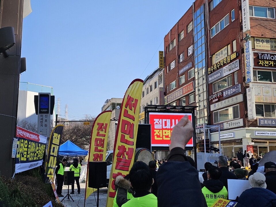 집회 현장 한편에 ‘전면철회 안 하면 죽음뿐’, ‘과천이 죽는다 9800세대 폭탄’ 등의 대형 현수막이 걸려 있다. 정부의 주택 공급 계획에 대한 지역 반발이 현장 곳곳에 드러났다.<br>